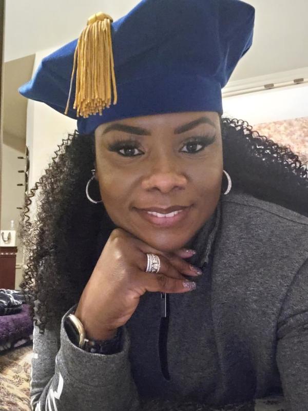 A woman in a graduation hat posing for a photo.