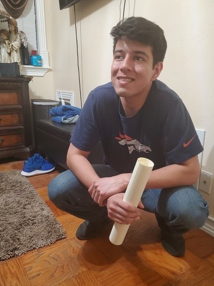 A man crouching down holding a roll of toilet paper.