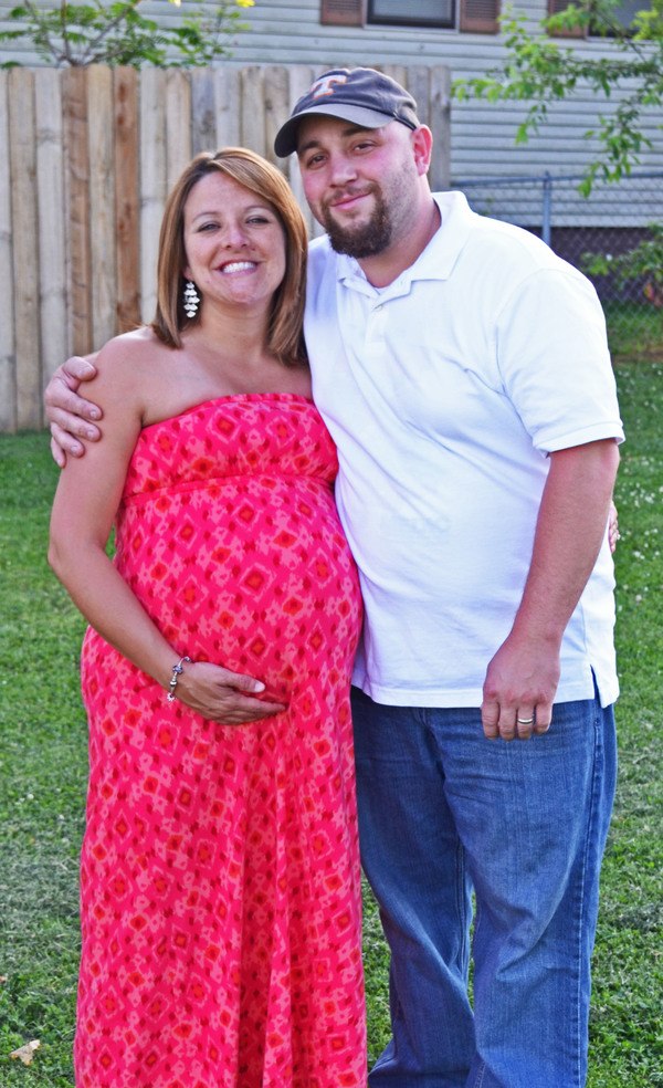 A pregnant man and woman posing for a photo.