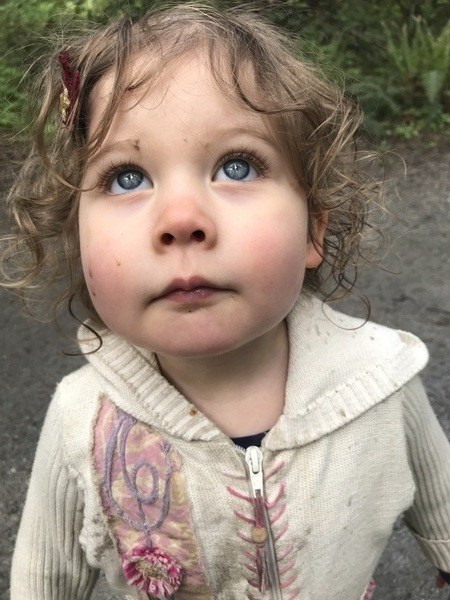 A little girl with blue eyes looking at the camera.