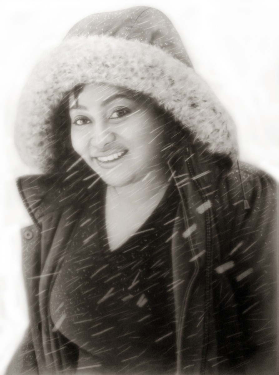 A black and white photo of a woman in the snow, captured in a charcoal light style.