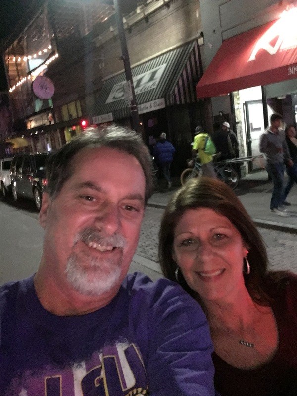 A man and woman taking a selfie on the street at night.