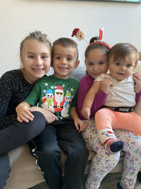 Four children posing for a picture on a couch.