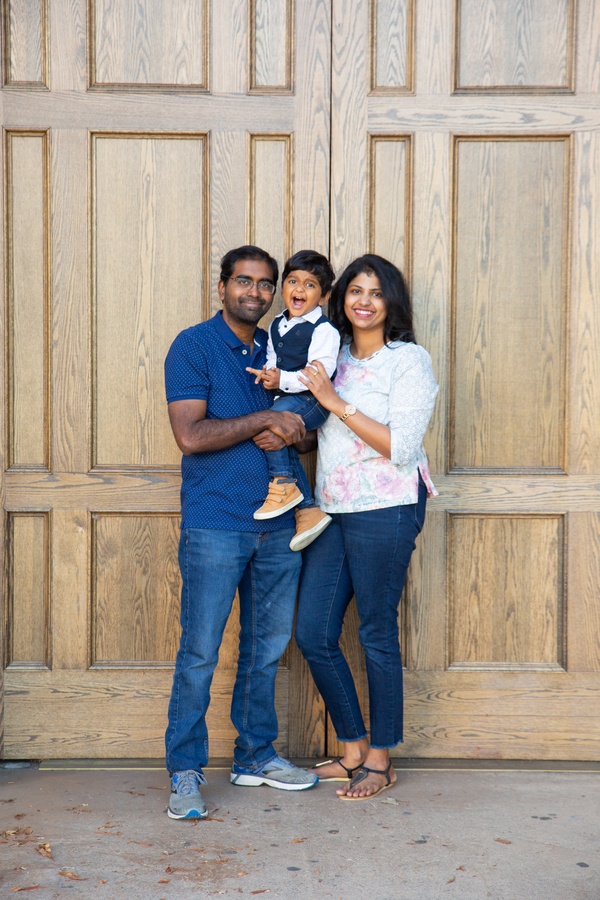A family posing in front of a wooden door.