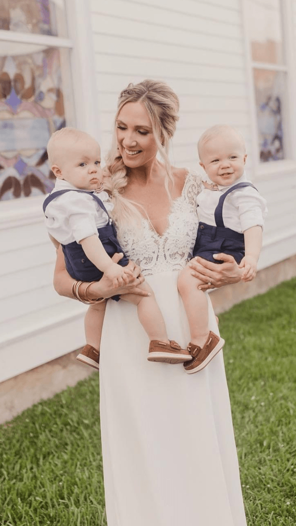 A bride holding her two sons in front of a church.