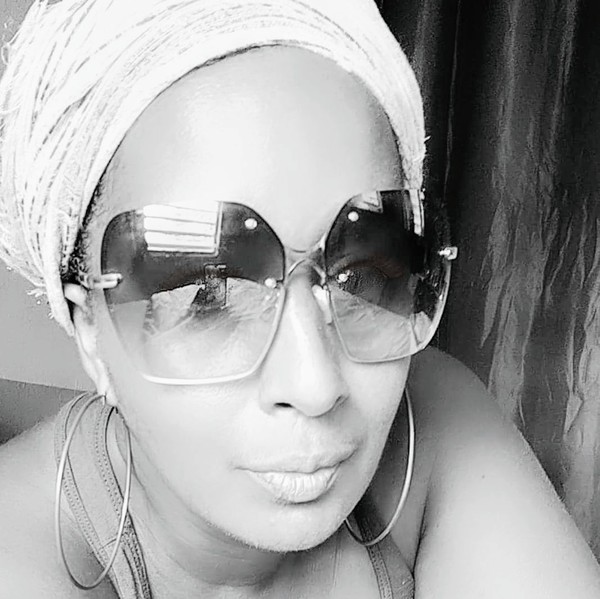 a person wearing sunglasses and a head wrap