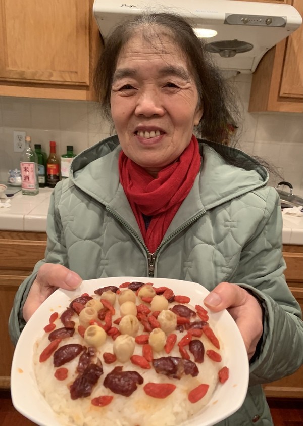 An asian woman holding a plate of food.