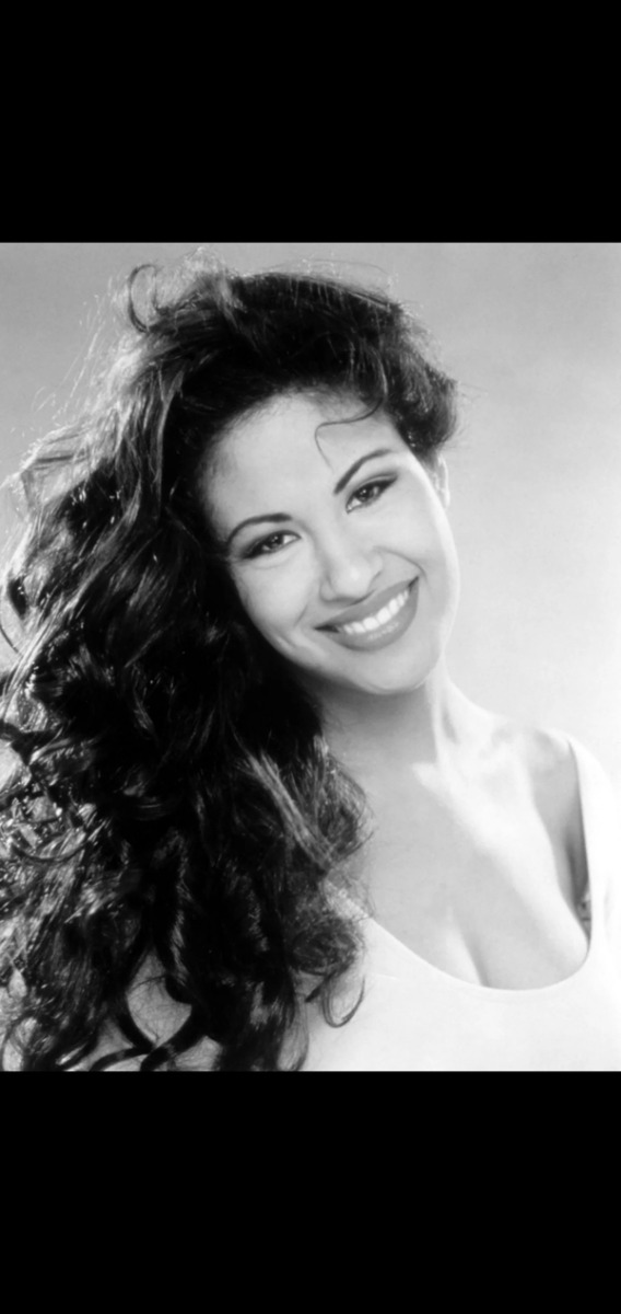 A black and white photo of a woman smiling.