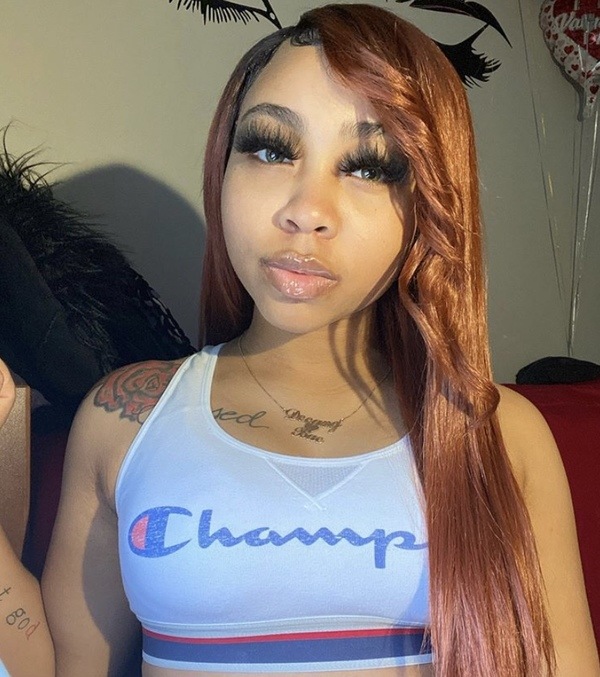 A woman wearing a bra top with the champion logo on it.