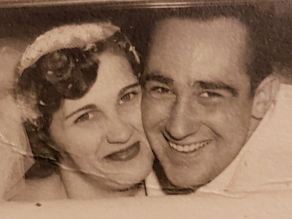 An old photo of a man and woman smiling.