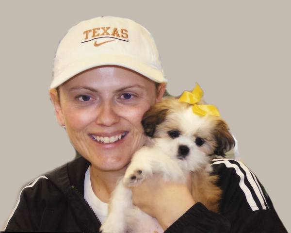 A woman holding a puppy in a hat.