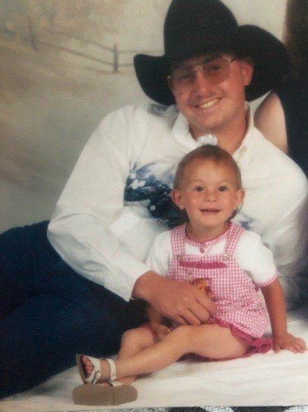A man in a cowboy hat and a little girl in a cowboy hat.