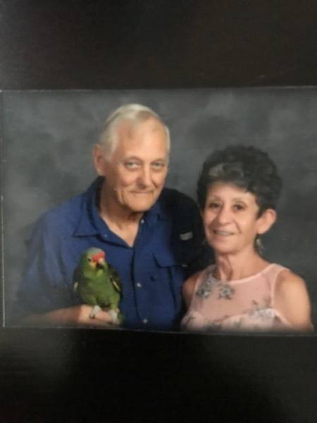 A picture of an older couple with a parrot.