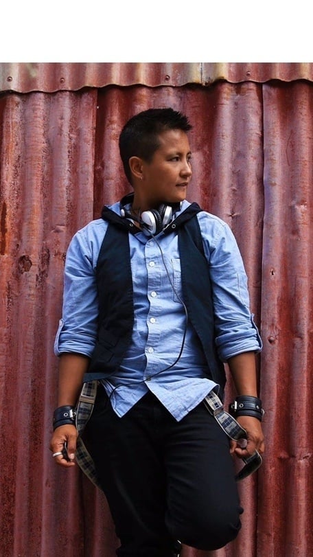 a person with headphones around neck posing for the camera